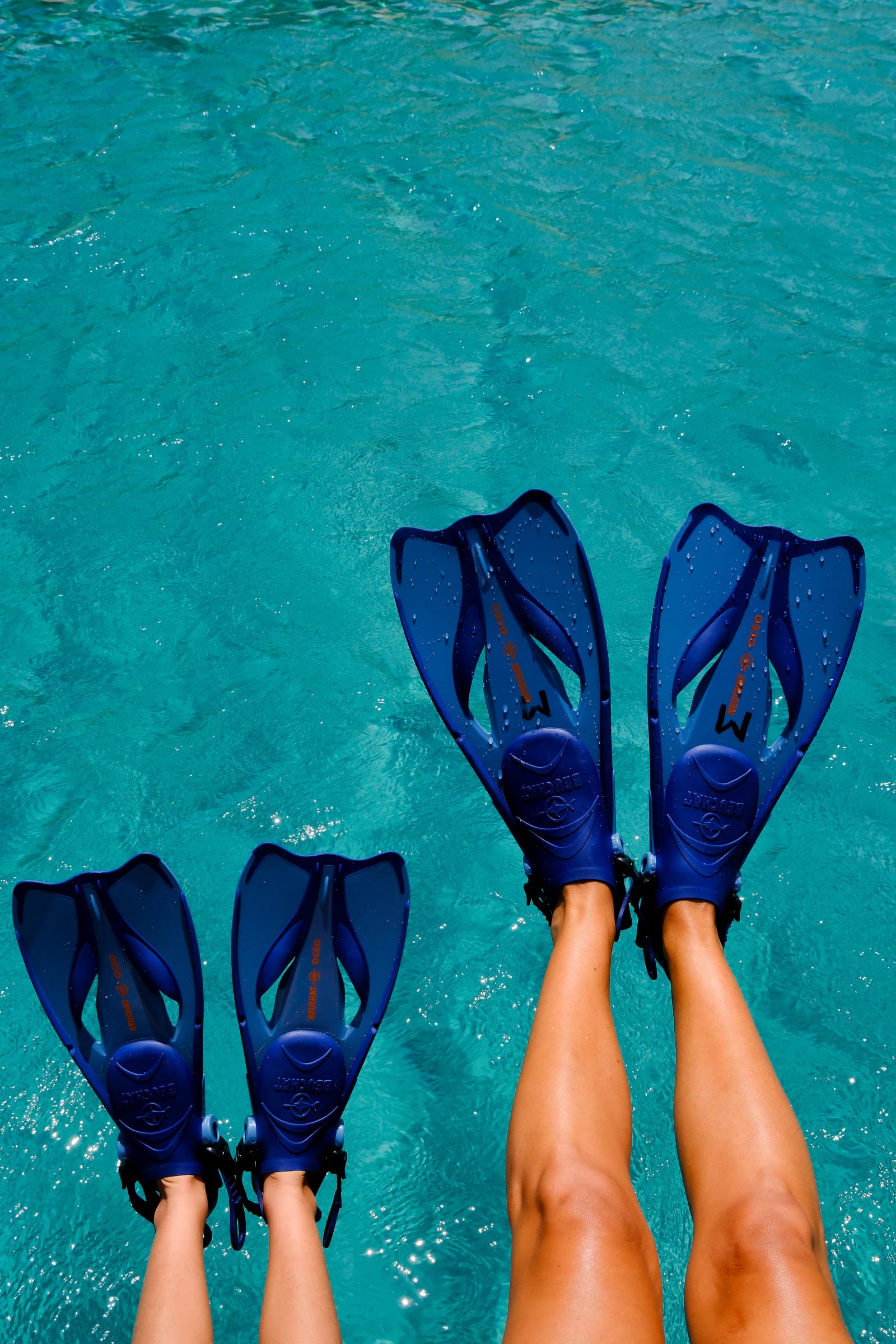 Deux paires de palmes au-dessus d’une eau turquoise